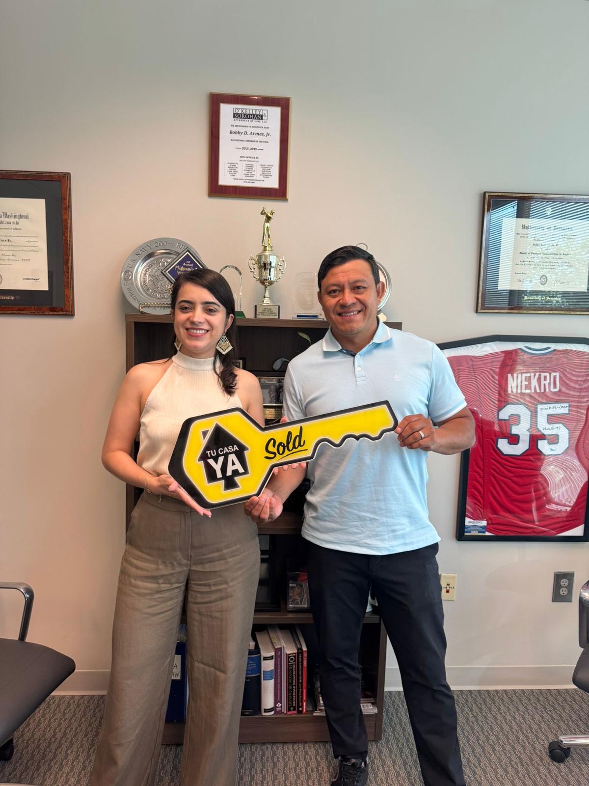 Pareja hispana celebrando la compra de su casa con préstamo FHA